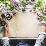 Florist Showing Empty Design Space Paper on Wooden Table with Fr